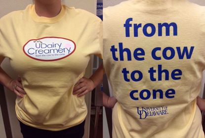 Photo of a UDairy Creamery t-shirt, yellow with the words From the Cow to the Cone on it.