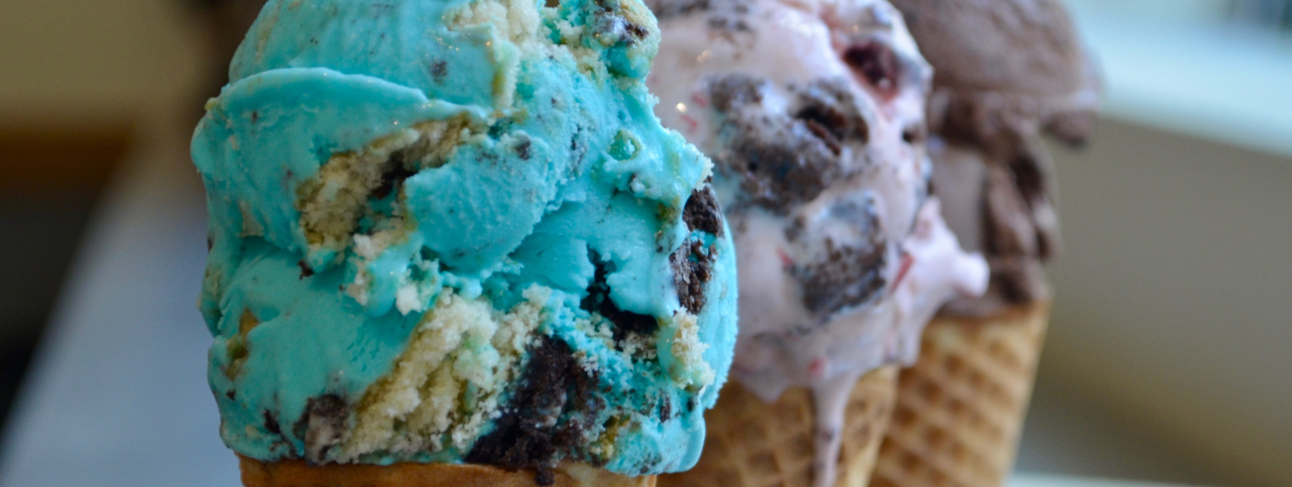 Three flavors of ice cream in three ccones.
